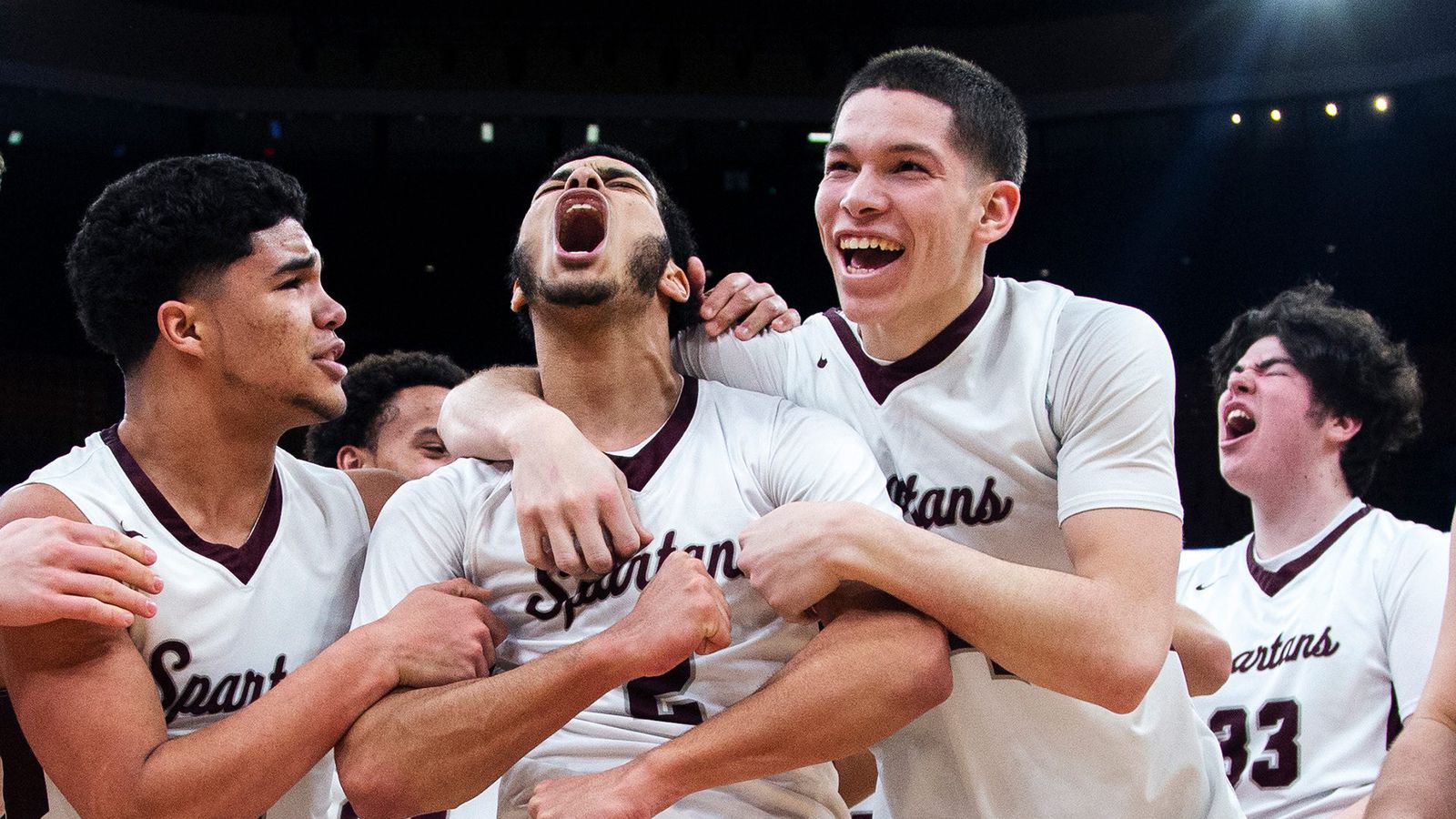 Basketball teammates scream and hug after a big play